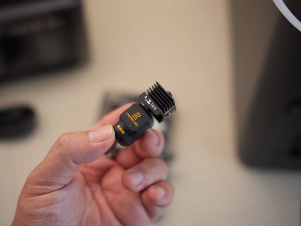 Hotend 300°C tháo nhanh — cảnh báo CAUTION HOT, đổi cỡ nozzle dễ.